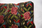 Hand-knotted pink rose and green leaf motif on the antique rug fragment pillow.