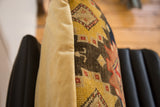 Golden yellow velvet backing and abrash geometric design on antique rug fragment pillow side.