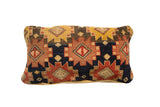 Antique Rug Fragment Pillow with vibrant geometric patterns and warm yellow abrash.