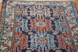 Distressed copper red and navy blue geometric rams horn motifs on a vintage Lilihan rug.