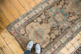 Distressed antique Caucasian rug, worn texture reveals geometric patterns in sky blue, brown, pink.