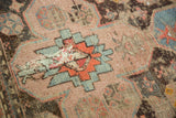 Antique Caucasian rug detail: distressed geometric pattern in sky blue, orange, and soft pink.
