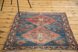 Distressed antique Persian rug featuring abrash, serrated terra cotta medallion, and hooked guls.