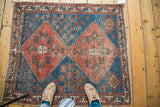 Serrated terra cotta medallion and geometric border on a distressed antique Persian rug.