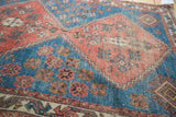 Distressed madder red stepped medallion and sky blue field with pinwheel floral motifs.