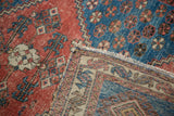 Distressed madder red and blue geometric pile detail with its woven reverse.