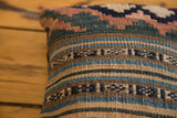 Faded blue, brown, and deep geometric patterns on woven antique Kilim pillow.