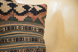 Woven side view of antique Kilim pillow, displaying its faded geometric patterns.