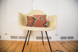 Two handmade Kilim pillows, featuring faded terracotta, blue, and black geometric designs.