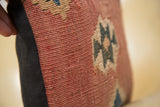Handmade Kilim pillow with faded red flatweave texture and black linen backing.