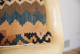 Faded blues, browns, and tan geometric motifs on a circa 1915 Kilim pillow corner.