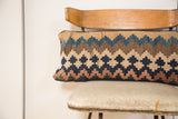 Faded early 20th century geometric patterns on an antique Kilim lumbar pillow in blues and earthy hues.
