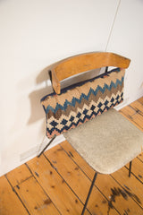 Antique Kilim lumbar pillow showing its faded geometric weave and navy backing.