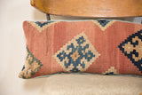 Faded reddish-orange and deep blue geometric design on antique hand-woven Kilim pillow.