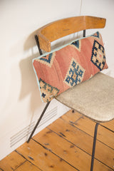 Antique Kilim lumbar pillow end, faded coral and blue geometric pattern, light blue linen.