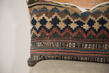 Early 20th century Kilim pillow's faded geometric patterns and woven texture.