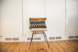 Antique Kilim lumbar pillow with faded geometric bands in blue, brown, and soft rose.