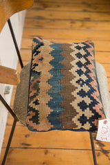 Antique Kilim lumbar pillow's corner, softened geometric pattern, navy backing, and product tag.