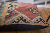 Antique Kilim floor pillow: faded rust, blue, beige geometric pattern and black linen.