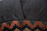 Black European linen back and antique Kilim fragment featuring geometric earth tones.