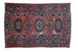 Distressed hand-knotted Lilihan rug with worn red field and blue floral palmette pattern.