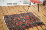 Distressed Persian Lilihan rug with red, blue, teal, intricate floral medallions.