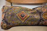 Unique purple Bibikabad rug fragment pillow, featuring intricate orange, green, and gold floral patterns.