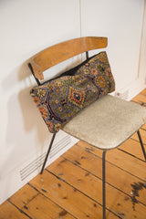 Purple Persian Bibikabad rug fragment pillow with intricate floral design and black linen back.