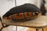Side view of purple Bibikabad lumbar pillow, highlighting rug fragment pile and black linen.