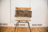 Purple Bibikabad lumbar pillow featuring intricate floral patterns in olive, orange, and blue.