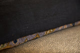 Black European linen pillow back with purple and gold Bibikabad rug fragment edge.