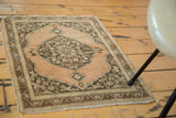 Antique Tabriz rug corner with soft abrashed copper field, scalloped spandrel, and leaf motif border.