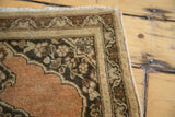 Scalloped charcoal spandrel and ivory meandering leaf border of a vintage Tabriz rug.