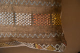 Cactus silk pillow, brown woven texture with geometric white, orange, yellow patterns.