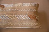 Textured cactus silk pillow showing natural, white, and orange zigzag embroidery patterns.