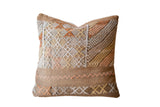 Repurposed cactus silk pillow displaying geometric patterns in warm orange, cream, and gold.