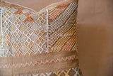 Textured cactus silk pillow showing geometric diamonds, zigzags, and earth tone colors.