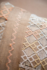 Textured tan cactus silk pillow with peach, gold, and white geometric patterns.