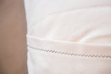 Off-white organic cotton canvas back with envelope closure and zig-zag stitch.