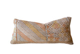 Repurposed sabra silk lumbar pillow with geometric patterns in muted orange, yellow, and beige.
