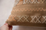 Cactus silk pillow with raised handwoven patterns, showcasing beige and peach geometric motifs.