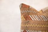 Woven brown cactus silk detail with colorful geometric zigzags and stripes.