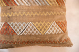 Textured cactus silk pillow with embroidered gold, white, and rust geometric patterns.