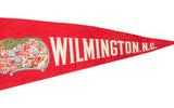 White WILMINGTON, N.C. lettering on a vintage red felt banner with downtown buildings graphic.