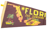 Angled detail of vintage Florida felt banner with map outline, sun, palm tree, and flamingo.