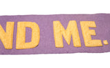 Detail of hand-sewn yellow letters on soft purple wool felt vintage banner.