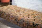 Muted purple Bibikabad rug fragment with intricate floral motifs on the vintage ottoman.