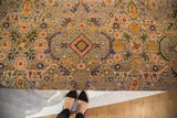 Detailed purple Bibikabad Persian rug pattern featuring peach, gold, and navy floral motifs on the ottoman.