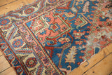 Antique Serapi runner fragment: tattered edge, worn pile, visible foundation, blue and blush.