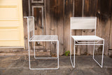 Pair of white vintage 1970s Flyline spaghetti chairs, slender metal frames.